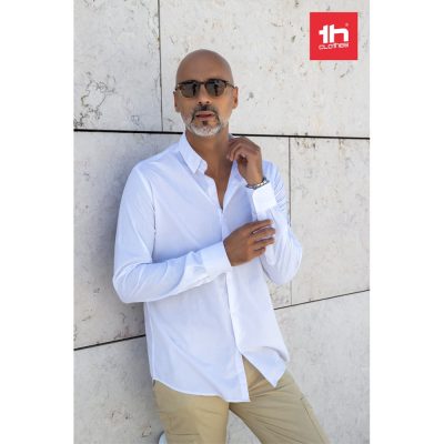 Camisa popelina de manga comprida com uma prega para homem em 35% algodão e 65% poliéster (115 g/m²). Contém botão invisível para firmeza do colarinho